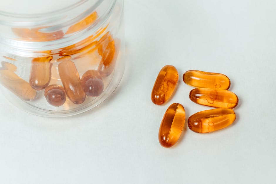 Supplement Purity and Potency Testing: What to Look for in Products glass container with amber capsules spilling out on a white